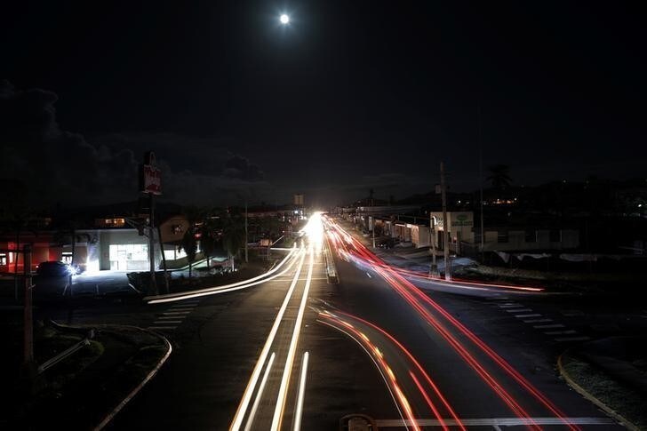 Cars drive in the darkness in a neighbourhood that has no electricity, after Hurricane Maria in Caguas, Puerto Rico October 4, 2017. Picture taken with long exposure. REUTERS/Carlos Barria