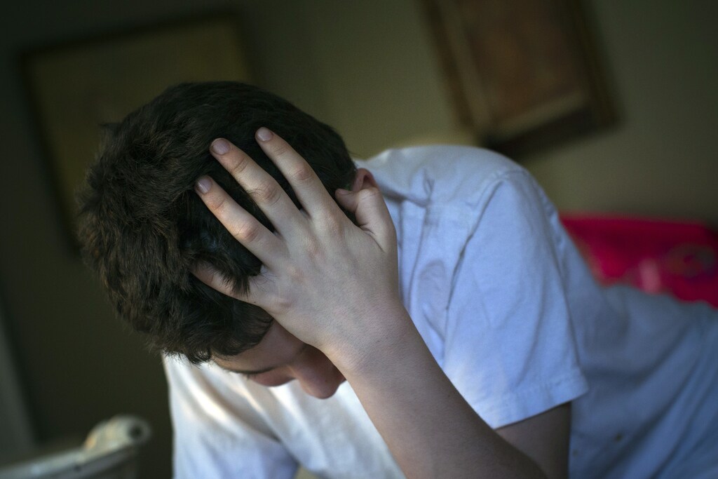 Matthew Kolen, who was diagnosed at age eight with Asperger's syndrome, puts his hand over his head while doing his homework in Long Island, New York April 16, 2012. Matthew's diagnosis will soon be dropped in the fifth edition of the Diagnostic and Statistical Manual of Mental Disorders or DSM-5, the American Psychiatric Association's diagnostic reference book, to be subsumed into the broader category of autism spectrum disorder. Picture taken April 16. REUTERS/Shannon Stapleton (UNITED STATES - Tags: SOCIETY HEALTH)