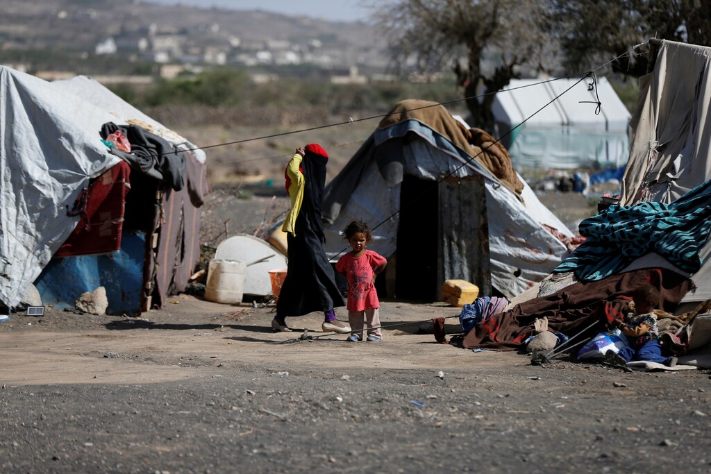 A woman walks past a child at a camp for people displaced by the war, near Sanaa, Yemen April 25, 2017. REUTERS/Khaled Abdullah - RTS13T4O