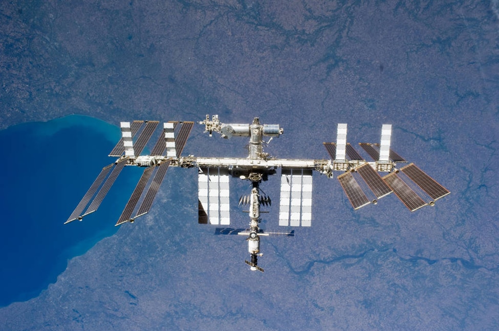 The International Space Station, photographed by an STS-131 crew member aboard Space Shuttle Discovery. The radiators which dispose of waste heat are the extended white rectangular arrays, while the solar panels are the darker and tilted. Note that the radiators are separate, large, and perpendicular to the solar arrays' orientation.