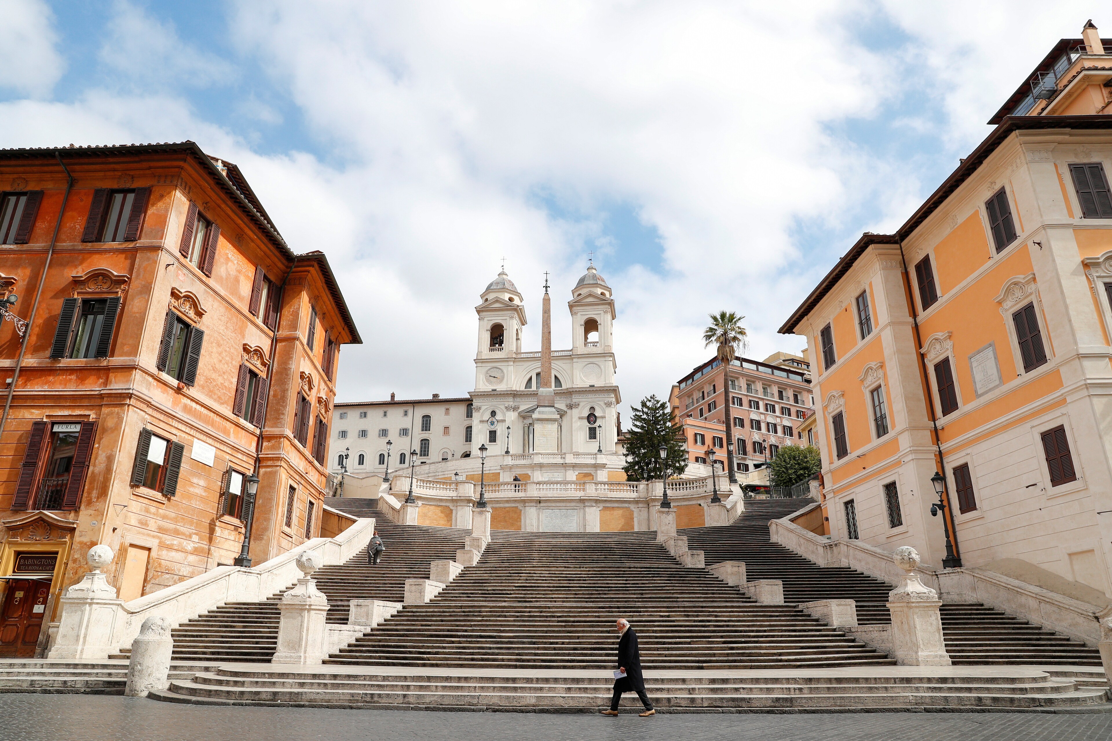 Un homme passe devant la Place d'Espagne, vide, de Rome.