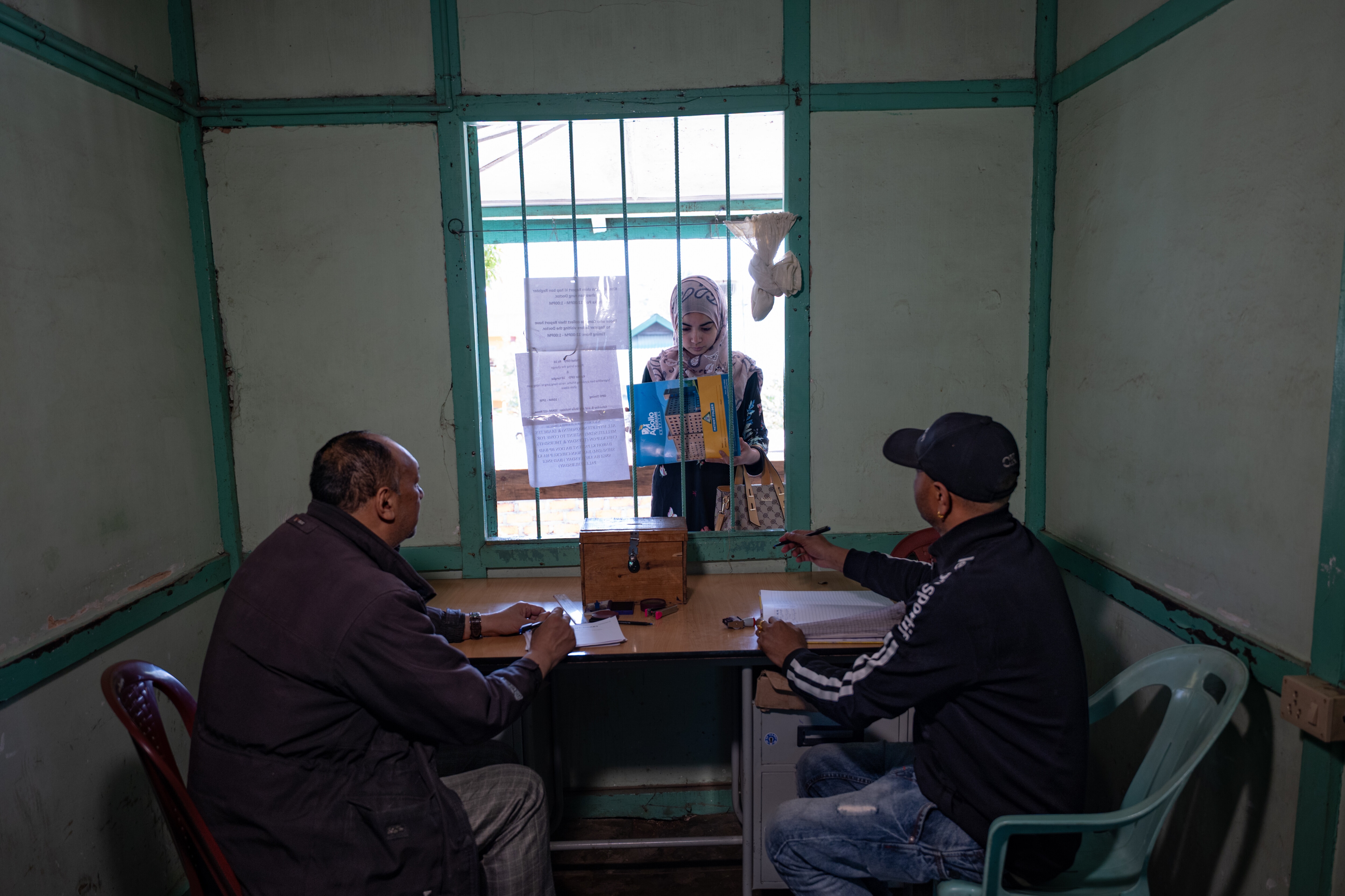 Patients wait at a registration and approvals desk at the Rynjah State Dispensary in Shillong.