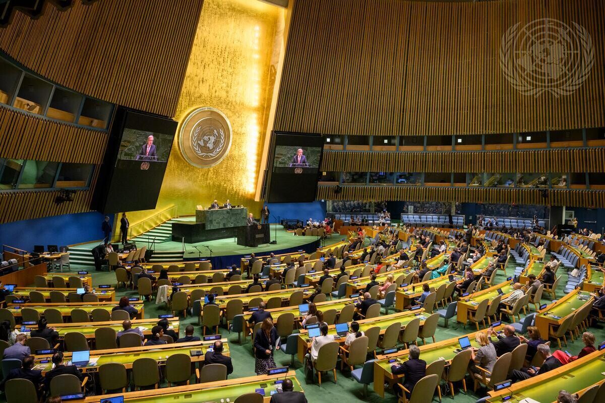 El secretario general António Guterres (en el podio y en las pantallas) se dirige a la reunión informal de la Asamblea General en sesión plenaria para conmemorar el 80.º aniversario de la firma de la Carta de las Naciones Unidas.