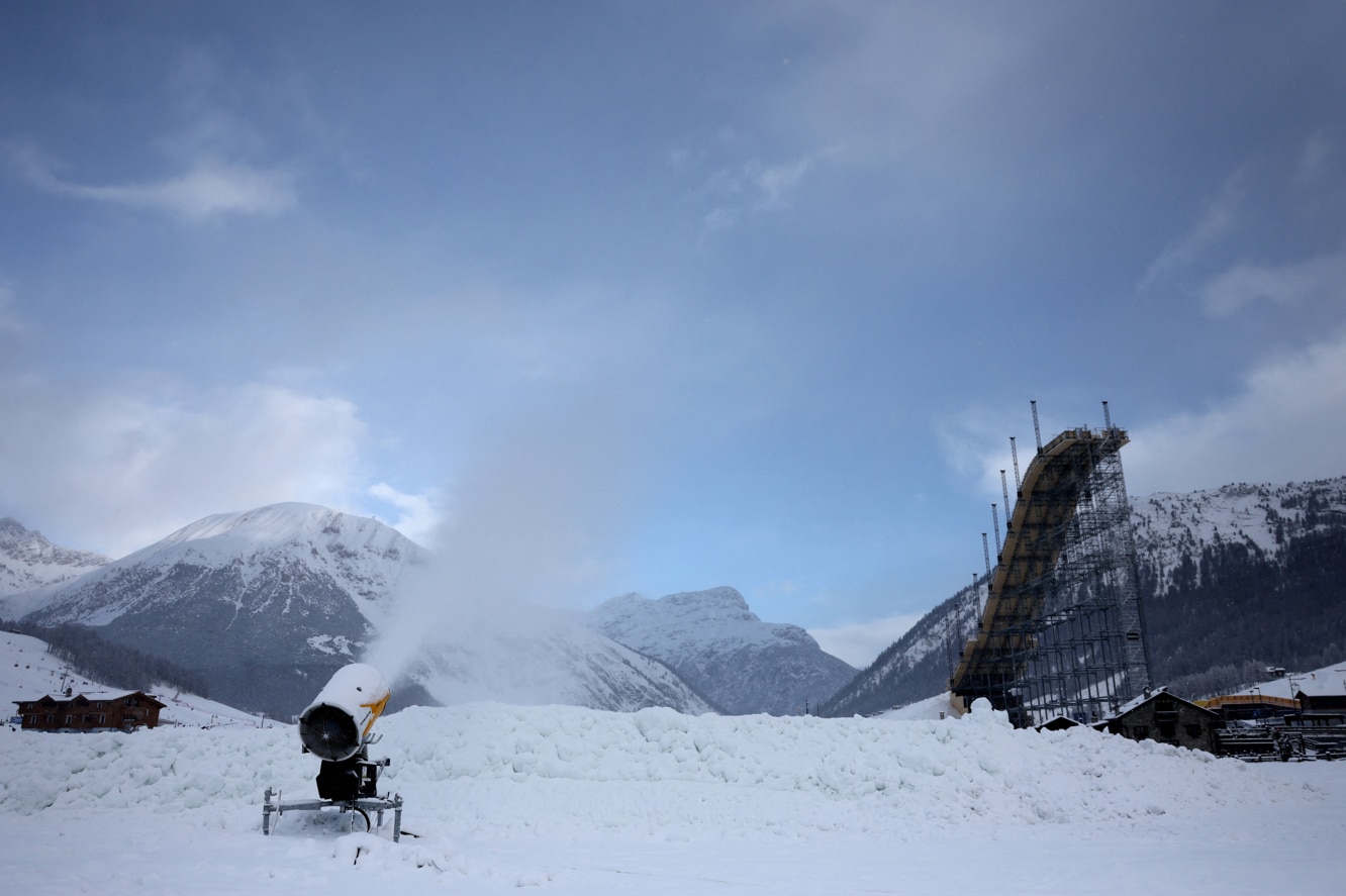 A snow cannon fires artificial snow infront of the big ski jump in the snow park in Livigno as part of the Milano Cortina Winter Olympic games in Italy, January 9, 2026. 