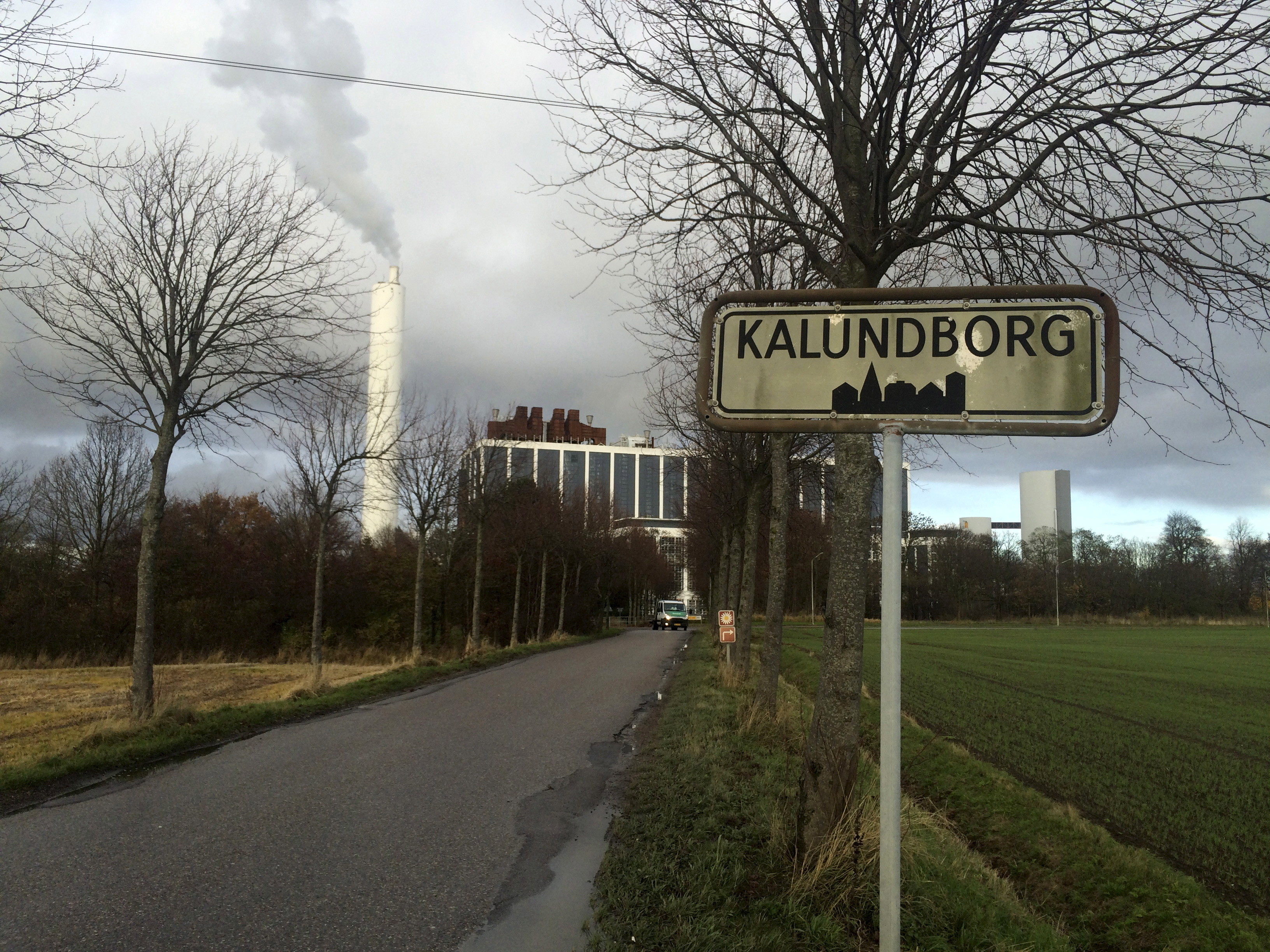 A car drives in front of DONG Energy's power station, which provides steam, ash and gypsum as waste products to other companies for their use in Kalundborg, Denmark, November 20, 2015. As pioneers of so-called industrial symbiosis, these companies swap waste and byproducts to cut costs and carbon dioxide (CO2) emissions profitably -- an approach that offers big business a financial incentive that could be crucial to nations striving to meet targets agreed at this month's global climate summit. Their success has attracted attention globally, with more than 30 corporate and municipal delegations from 20 countries visiting the town this year, including mayors from China's fast-growing Guandong province. To match story INDUSTRY-EMISSIONS/    REUTERS/Sabina Zawadzki - RTX1ZA4G         