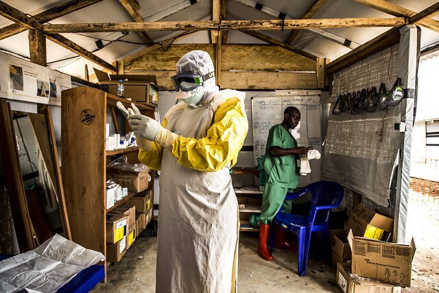 17 January 2019 - Beni, North Kivu region, Democratic Republic of Congo. Doctor Junior Ikomo puts the Personal Protective Equipment on, inlduing gloves, before going to treat patients who are suspected of being infected by Ebola.