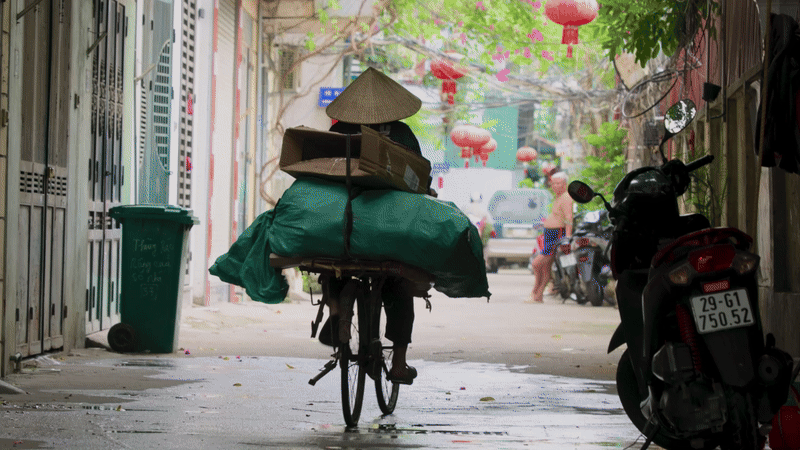 An informal waste collector cycles through Hanoi.