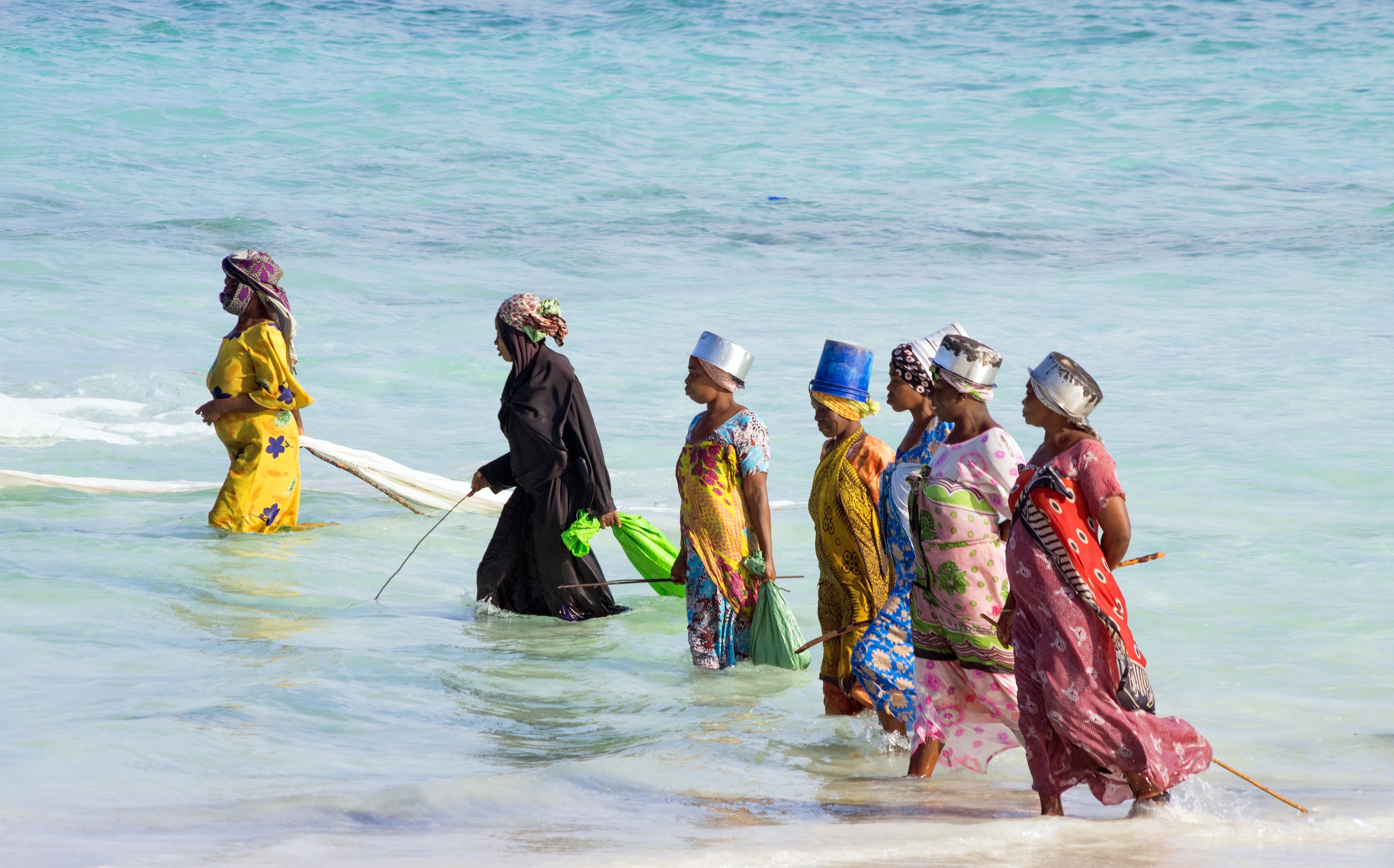 Zanzibar, Tanzania. Women from a fishing village are catching small fish off the coast of the ocean.