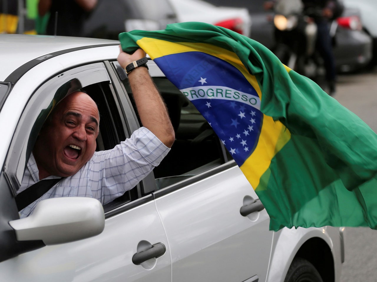 A supporter of Brazil's new president-elect, Jair Bolsonaro, celebrates in front of Bolsonaro's condominium at Barra da Tijuca neighborhood in Rio de Janeiro, Brazil October 29, 2018. REUTERS/Sergio Moraes