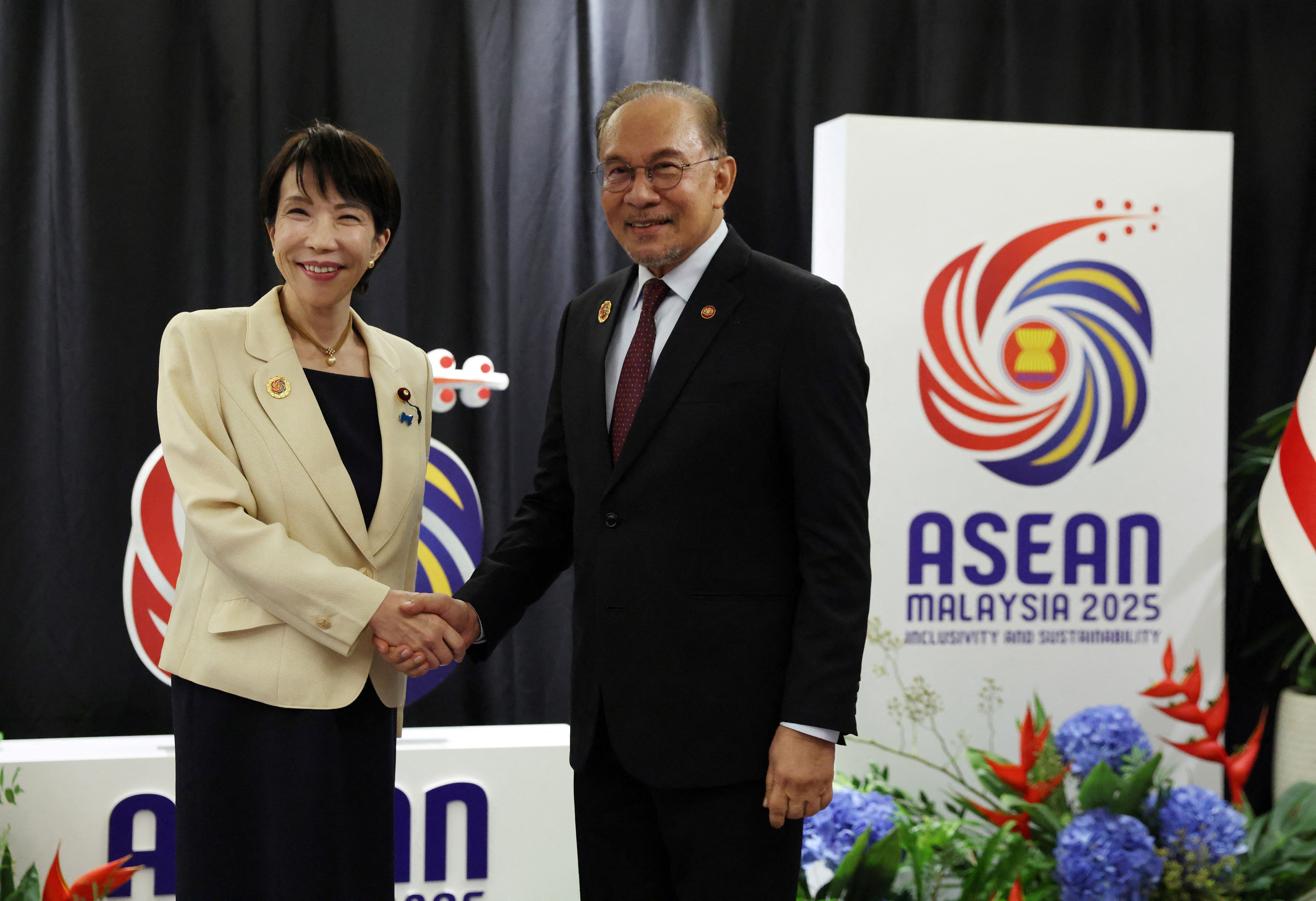 Japan's Prime Minister Sanae Takaichi shakes hands with Malaysia's Prime Minister and Finance Minister, Anwar Ibrahim, as ASEAN leaders attend the opening of the Association of Southeast Asian Nations (ASEAN) Summit at the Kuala Lumpur Convention Centre (KLCC) in Kuala Lumpur, Malaysia October 26, 2025. How Hwee Young/Pool via REUTERS
