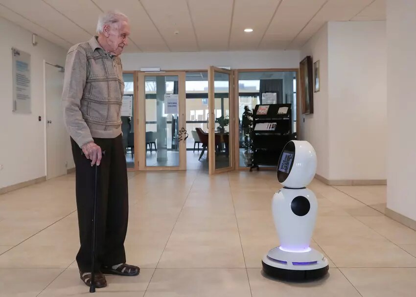 Le Belge Jozef Gouwy, 93 ans, regarde un robot fabriqué par la société belge ZoraBots.