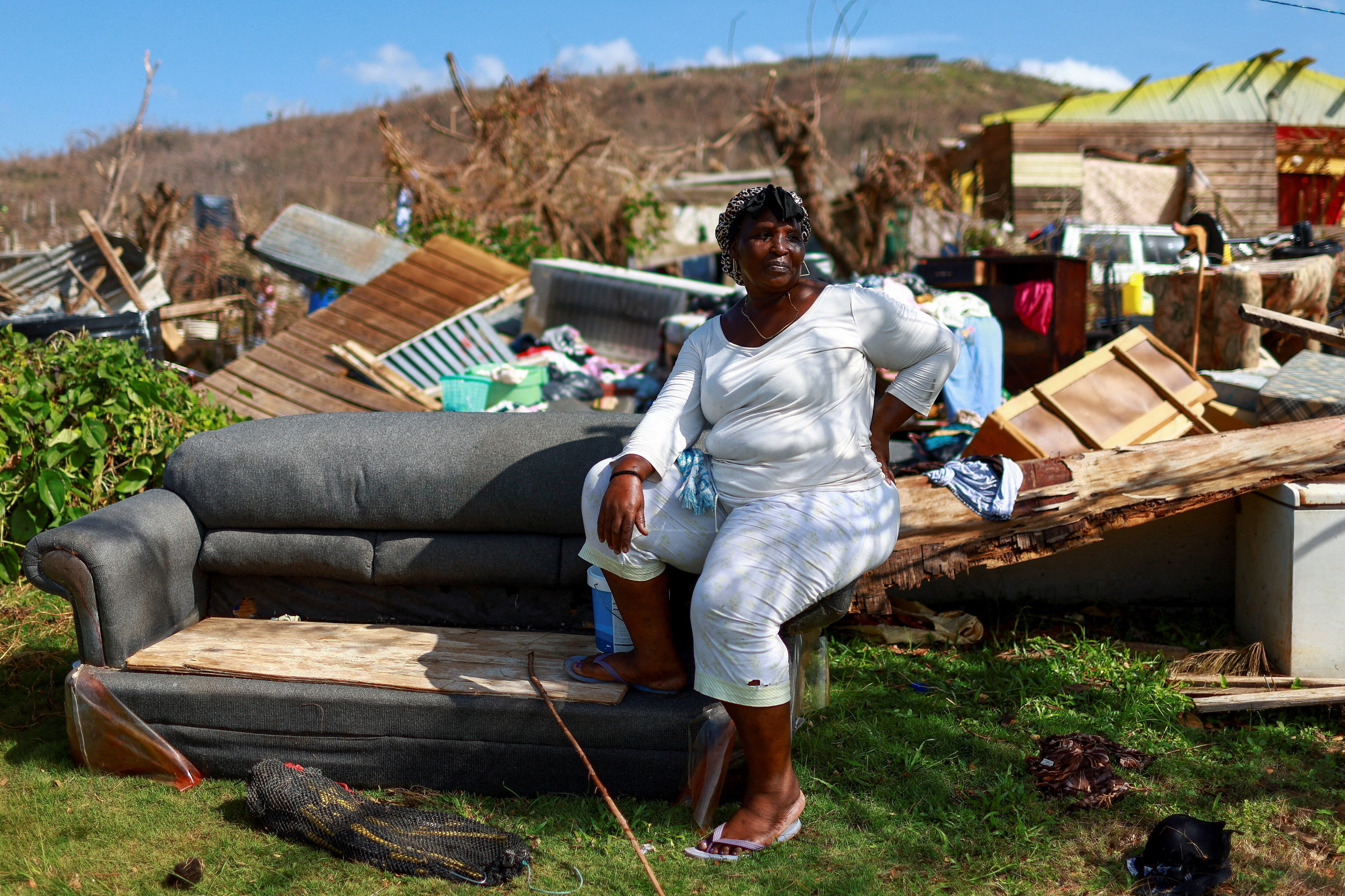 Jennafer Munari, 45, sits in front of the remains of her house destroyed by Hurricane Melissa in the aftermath of Hurricane Melissa in Auchindown, Saint Elizabeth Parish, Jamaica, November 3, 2025.