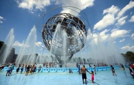 Des New-Yorkais se rafraîchissent à la fontaine Unisphere du Corona Park de Flushing Meadow, dans le quartier du Queens, le 21 juillet 2019.
