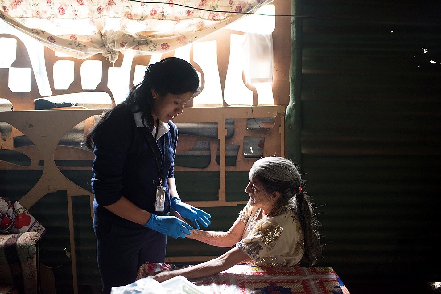 A medical practitioner assists an elderly lady.