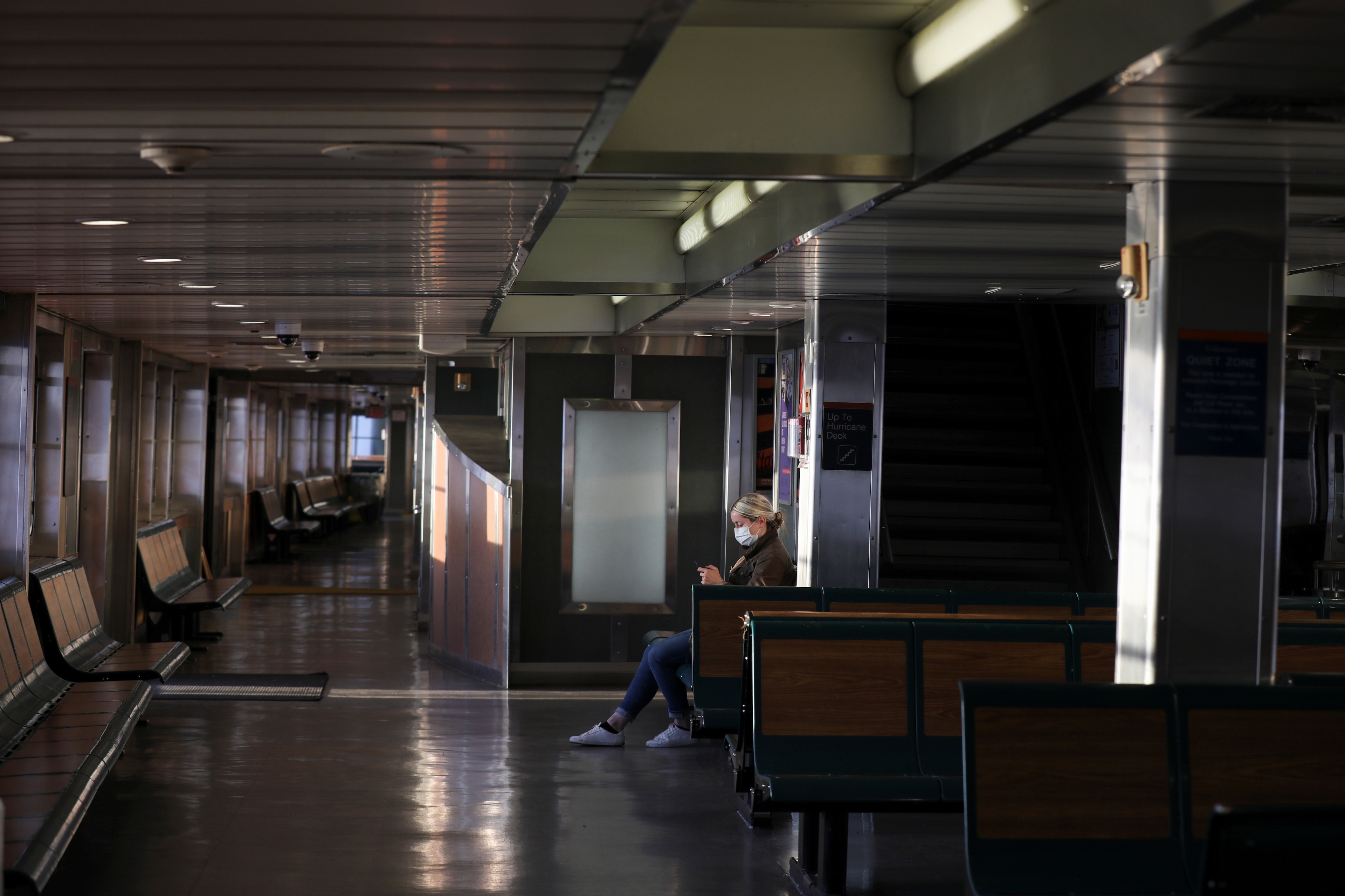 A commuter on the Staten Island Ferry wears a protective face mask and sits alone during the outbreak of the coronavirus disease (COVID-19) in Manhattan, New York City, U.S., March 26, 2020. REUTERS/Caitlin Ochs - Coronavirus china virus health healthcare who world health organization disease deaths pandemic epidemic worries concerns Health virus contagious contagion viruses diseases disease lab laboratory doctor health dr nurse medical medicine drugs vaccines vaccinations inoculations technology testing test medicinal biotechnology biotech biology chemistry physics microscope research influenza flu cold common cold bug risk symptomes respiratory china iran italy europe asia america south america north washing hands wash hands coughs sneezes spread spreading precaution precautions health warning covid 19 cov SARS 2019ncov wuhan sarscow wuhanpneumonia  pneumonia outbreak patients unhealthy fatality mortality elderly old elder age serious death deathly deadly 