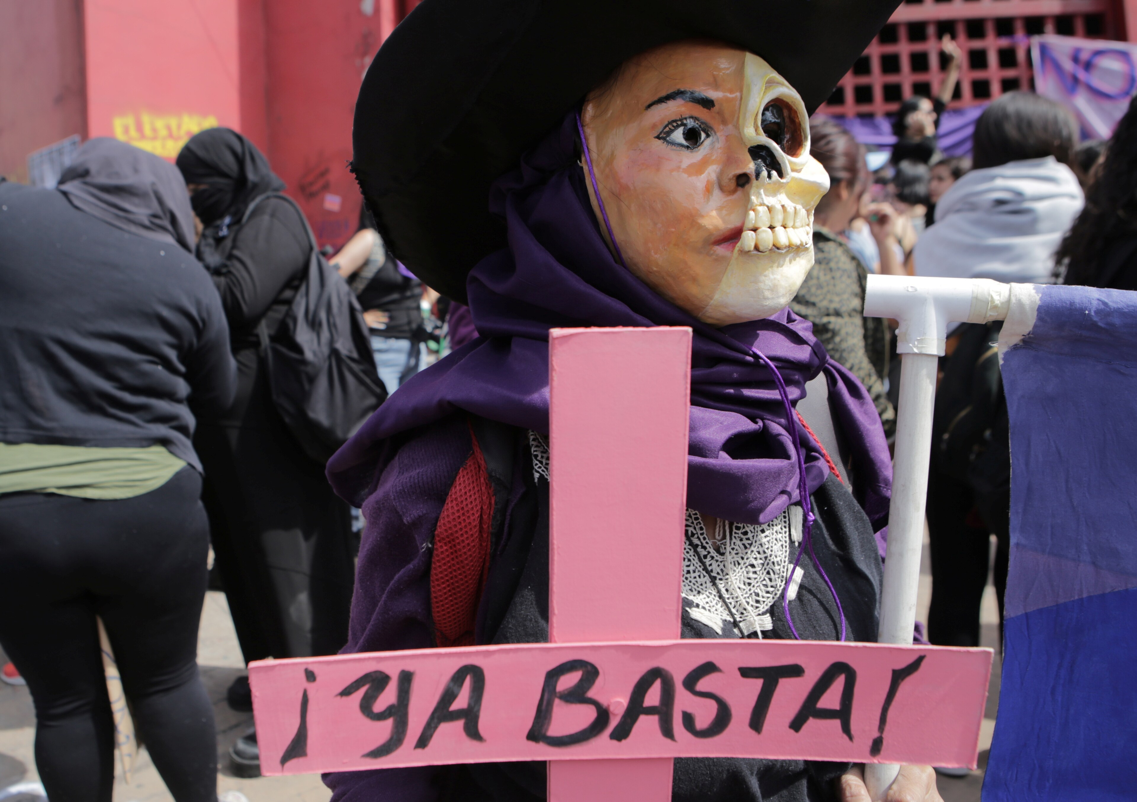 Une femme tient une croix rose avec l'inscription "Ça suffit !" pendant la Journée internationale de la femme à Ciudad Nezahualcoyotl, dans la banlieue de Mexico, Mexique, le 8 mars 2020.