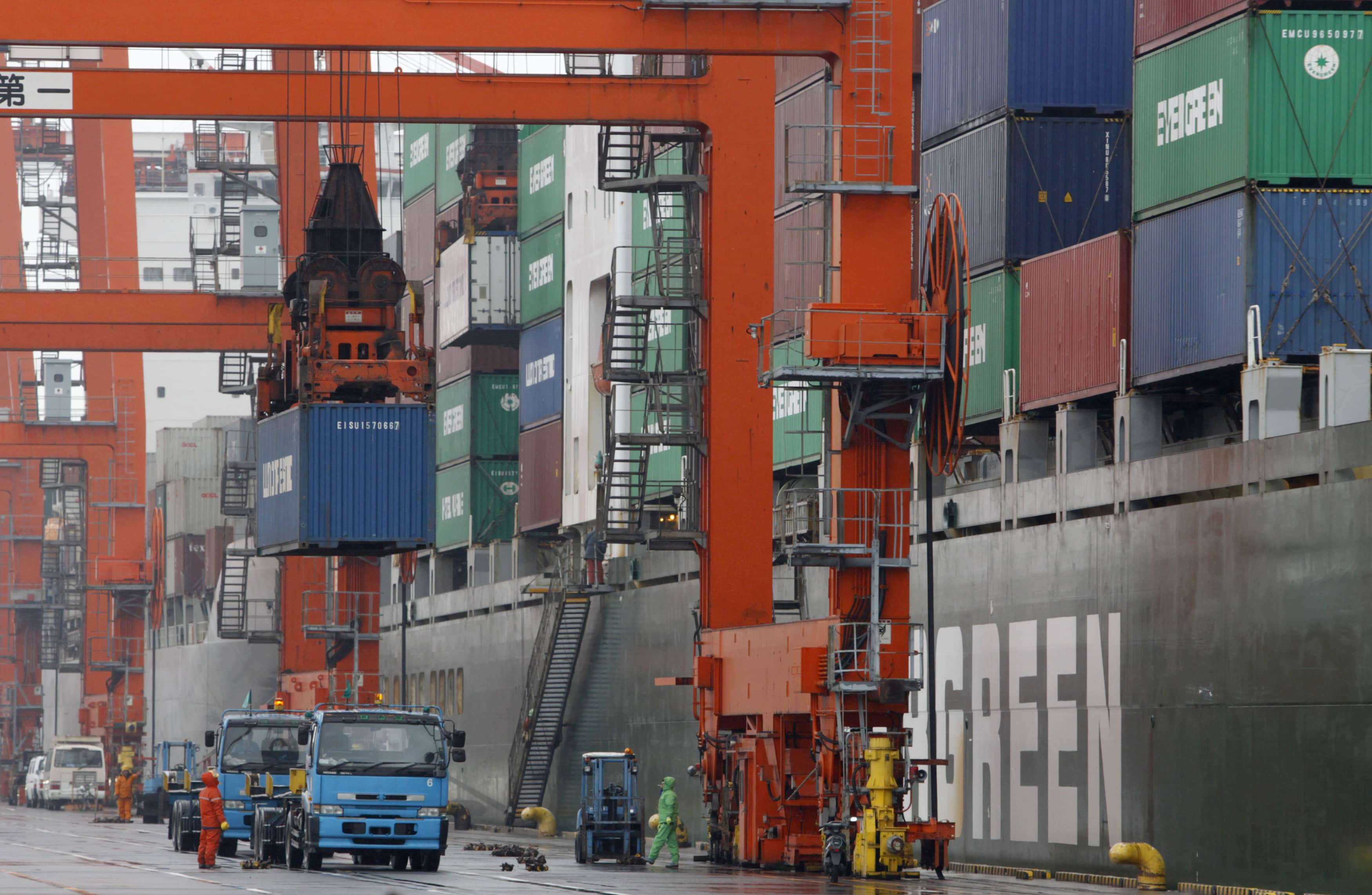 Workers load a cargo container on a truck at a pier in Tokyo March 24, 2010. Japan's exports fell in February from the previous month in a sign that a rebound in external demand could start to slow as the impact of subsidies and stimulus measures wane. REUTERS/Issei Kato (JAPAN - Tags: BUSINESS) - RTR2BZYB       