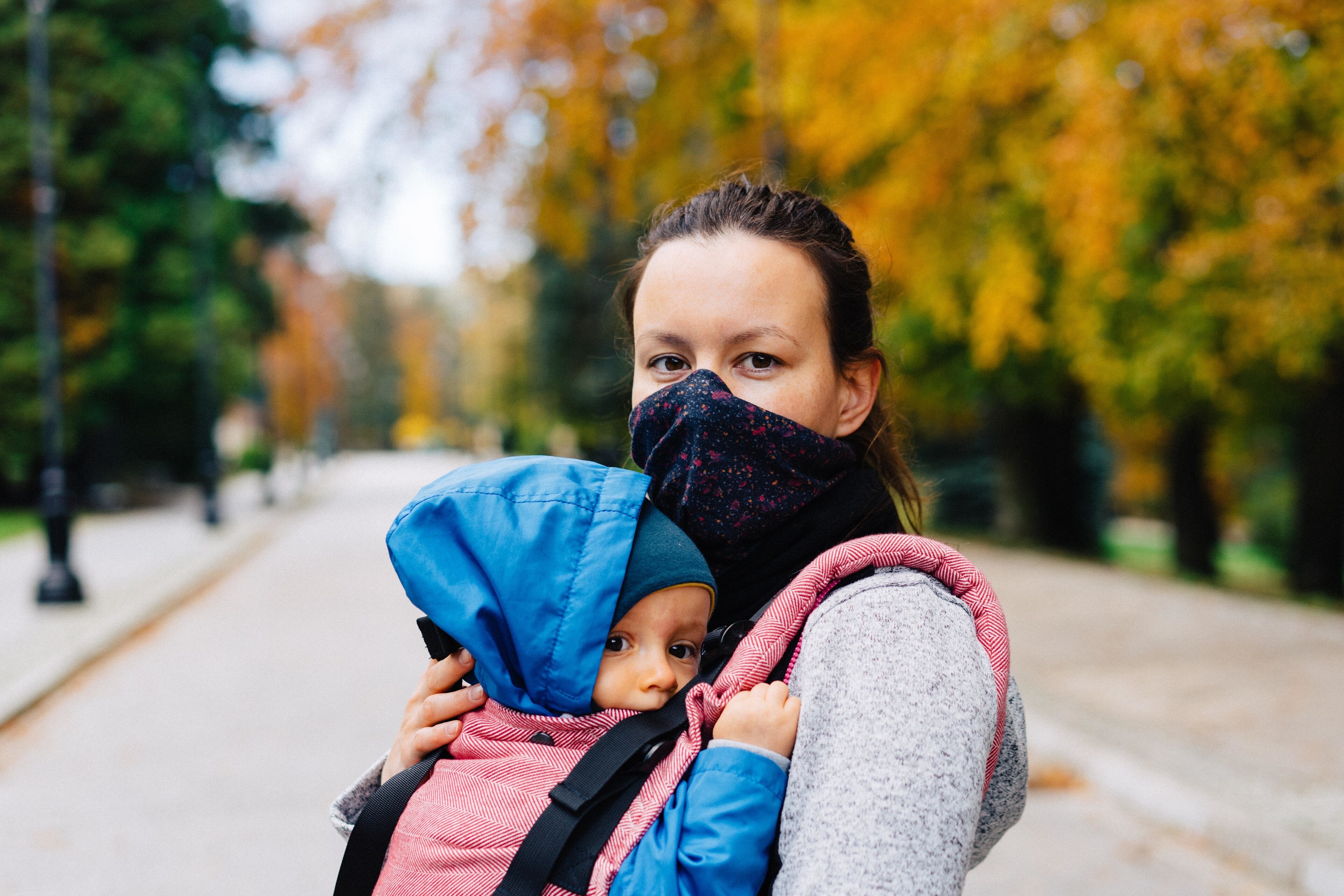 Masked mother holding child