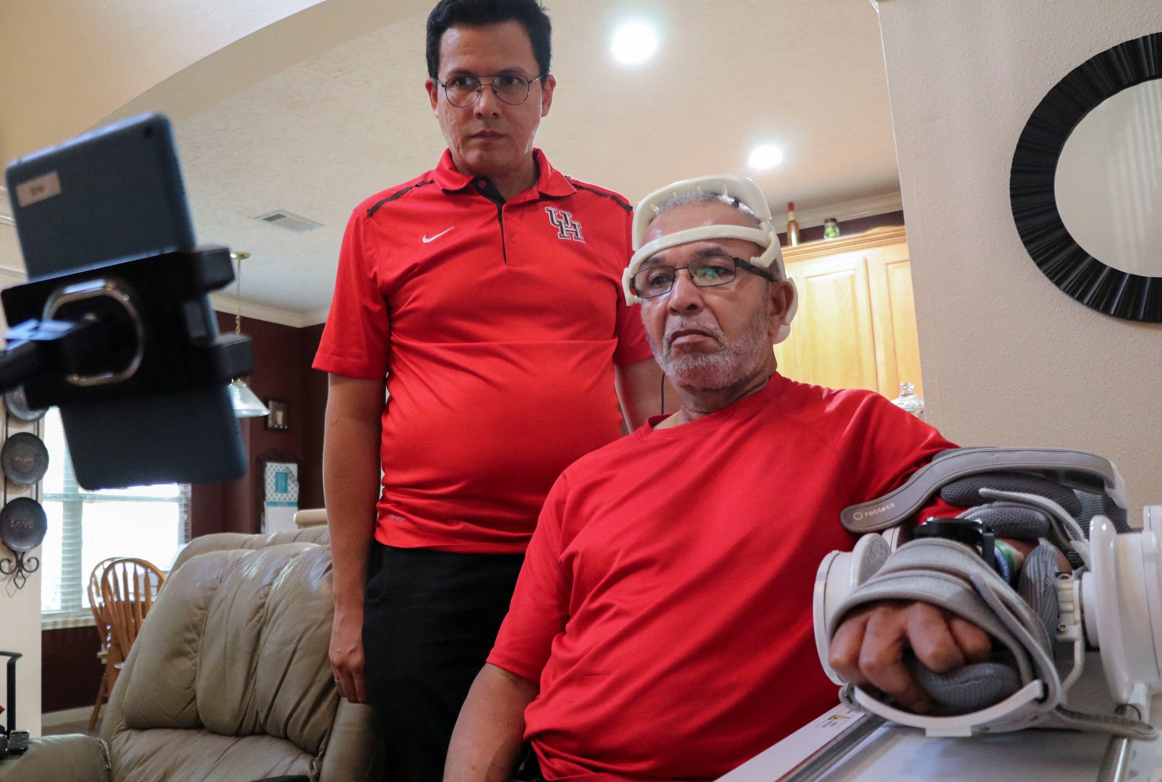 Oswald Reedus, superviviente de un accidente cerebrovascular, utiliza una interfaz cerebro-computadora conectada a un brazo robótico con la ayuda de José González-España, estudiante de doctorado en ingeniería eléctrica e informática de la Universidad de Houston, en Richmond, Texas, Estados Unidos, el 21 de septiembre de 2023.