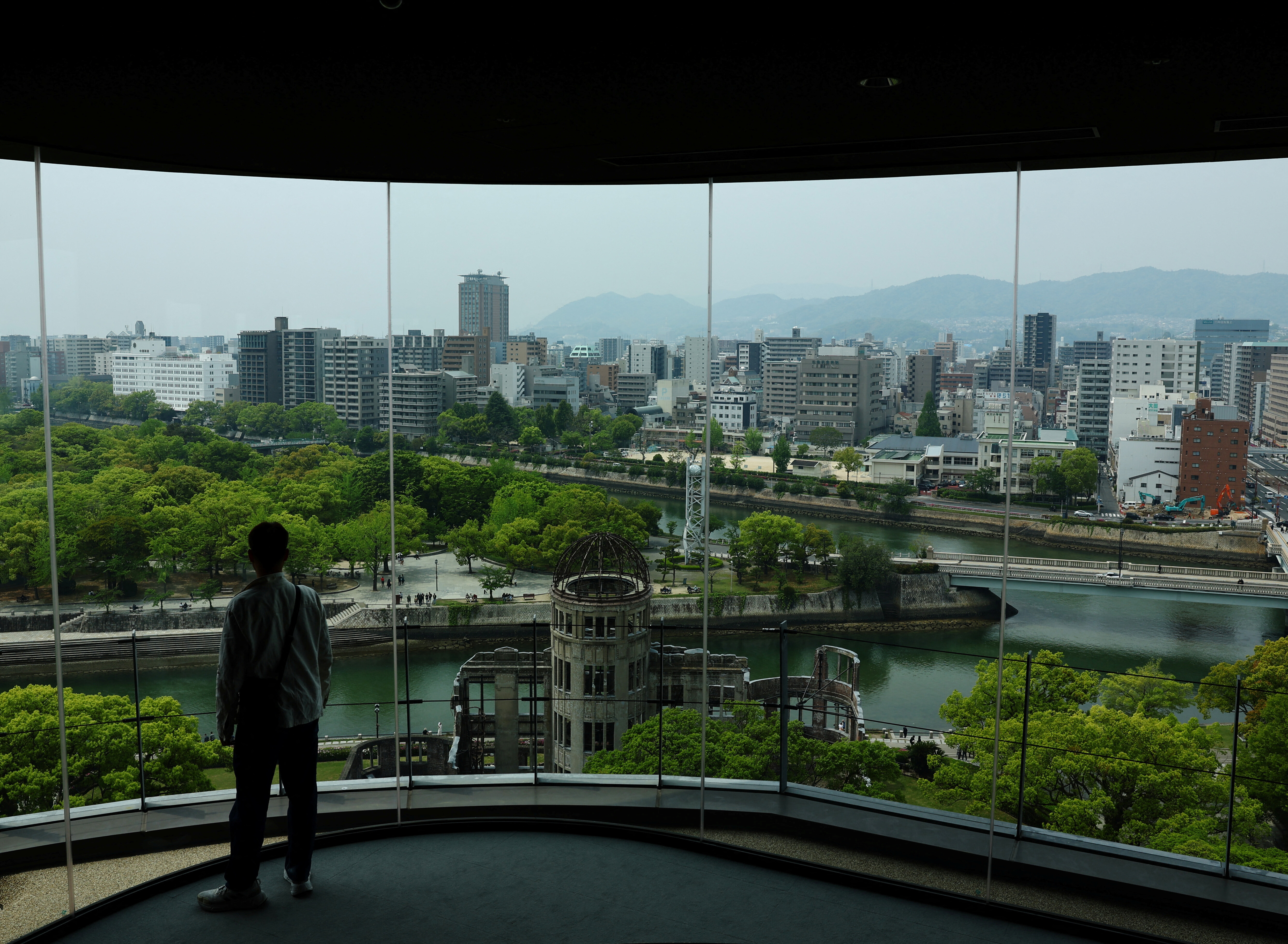 A man looks at the preserved Atomic Bomb Dome from an observation point near the Hiroshima Peace Memorial Park in Hiroshima, Japan, April 25, 2025.   REUTERS/Kim Kyung-Hoon To match Special Report JAPAN-SOUTHKOREA/USA-NUCLEAR