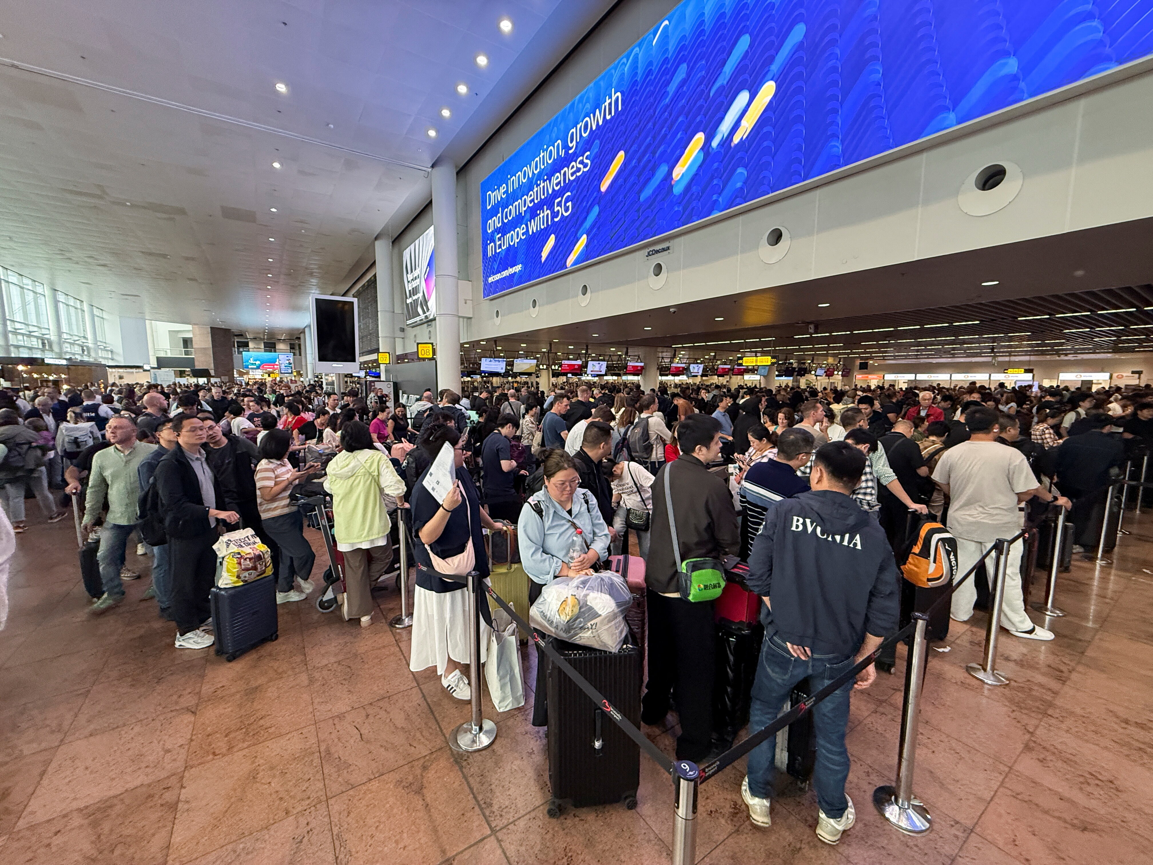 Travellers wait at Brussels airport, after a cyberattack at a service provider for check-in and boarding systems disrupted operations at several major European airports, in Zaventem near Brussels, Belgium September 20, 2025
