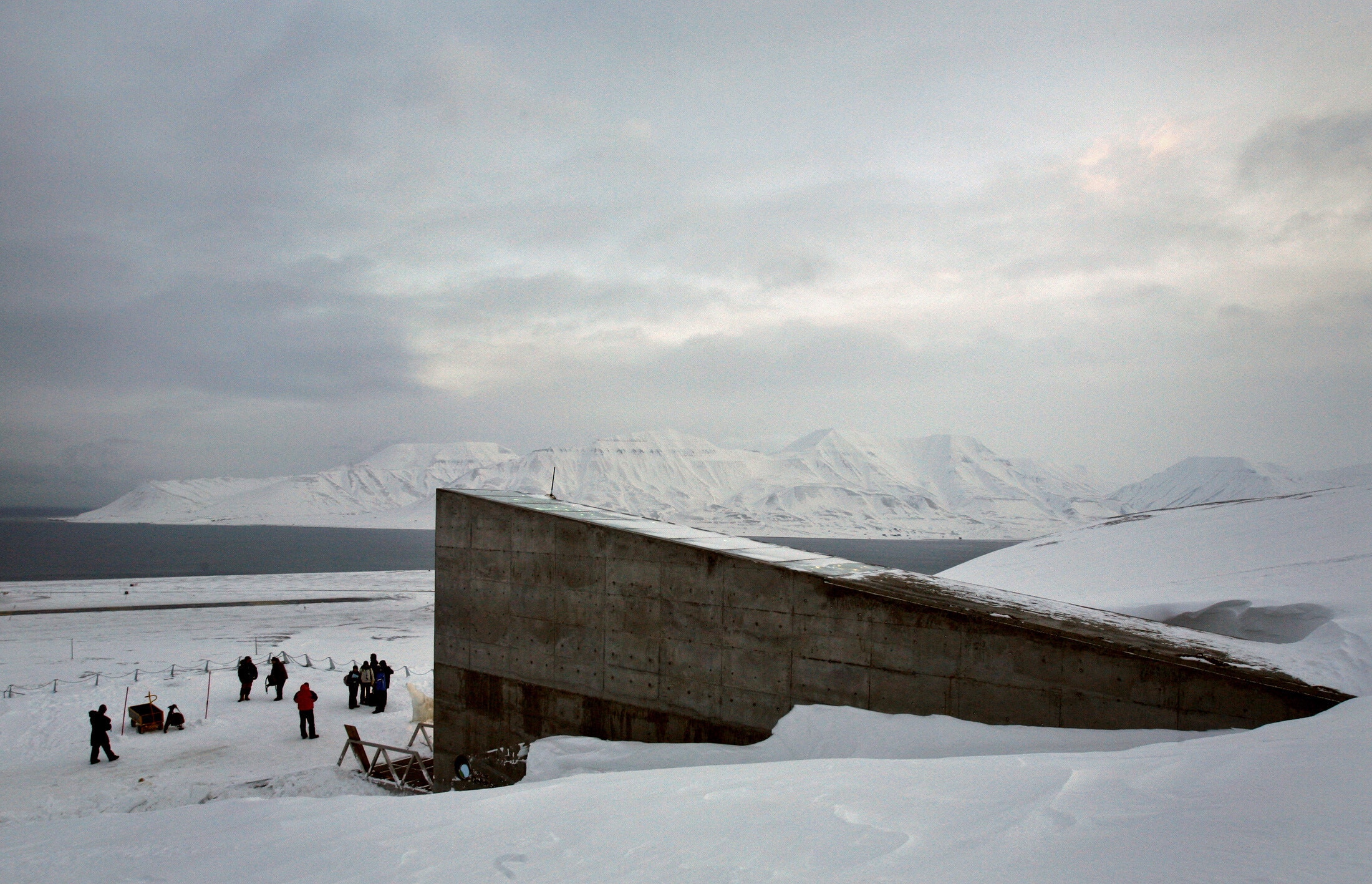 Journalists gather near the entrance to the Global Seed Vault in Longyearbyen February 25, 2008. The vault has been built in a mountainside cavern on Spitsbergen Island around 1,000 km (600 miles) from the North Pole to store the world's crop seeds in case of disaster. The official opening will take place February 26.   REUTERS/Bob Strong (NORWAY)