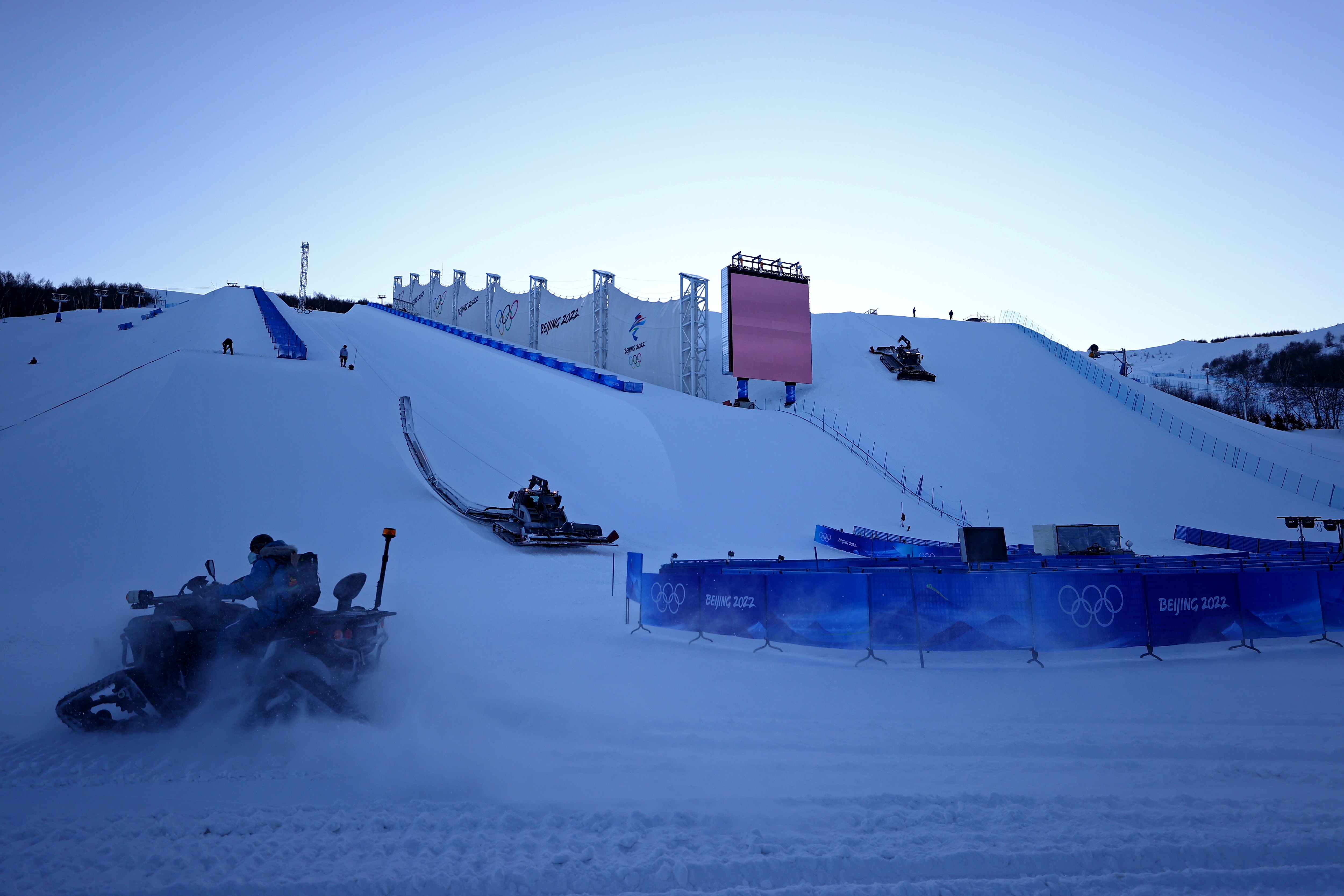 A snow mobile makes its way in front of the Halfpipe and Snowboard Cross venue at the Zhangjiakou Genting Snow Park ahead of the Beijing 2022 Winter Olympics in Zhangjiakou, China January 29, 2022.