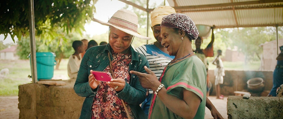 Mawuse Christina Gyisun (left) showing female farmers how to use Sommalife's digital platform.