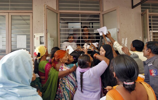 Woman jostle to enrol themselves for Unique Identification (UID) database system in the outskirts of the western Indian city of Ahmedabad February 14, 2013. The UID database, known as Aadhaar, will help directly transfer budget-busting subsidies to the poor, plugging in leakages in welfare spending. Picture taken February 14, 2013. To match INDIA-BUDGET/ REUTERS/Amit Dave (INDIA - Tags: BUSINESS TPX IMAGES OF THE DAY)