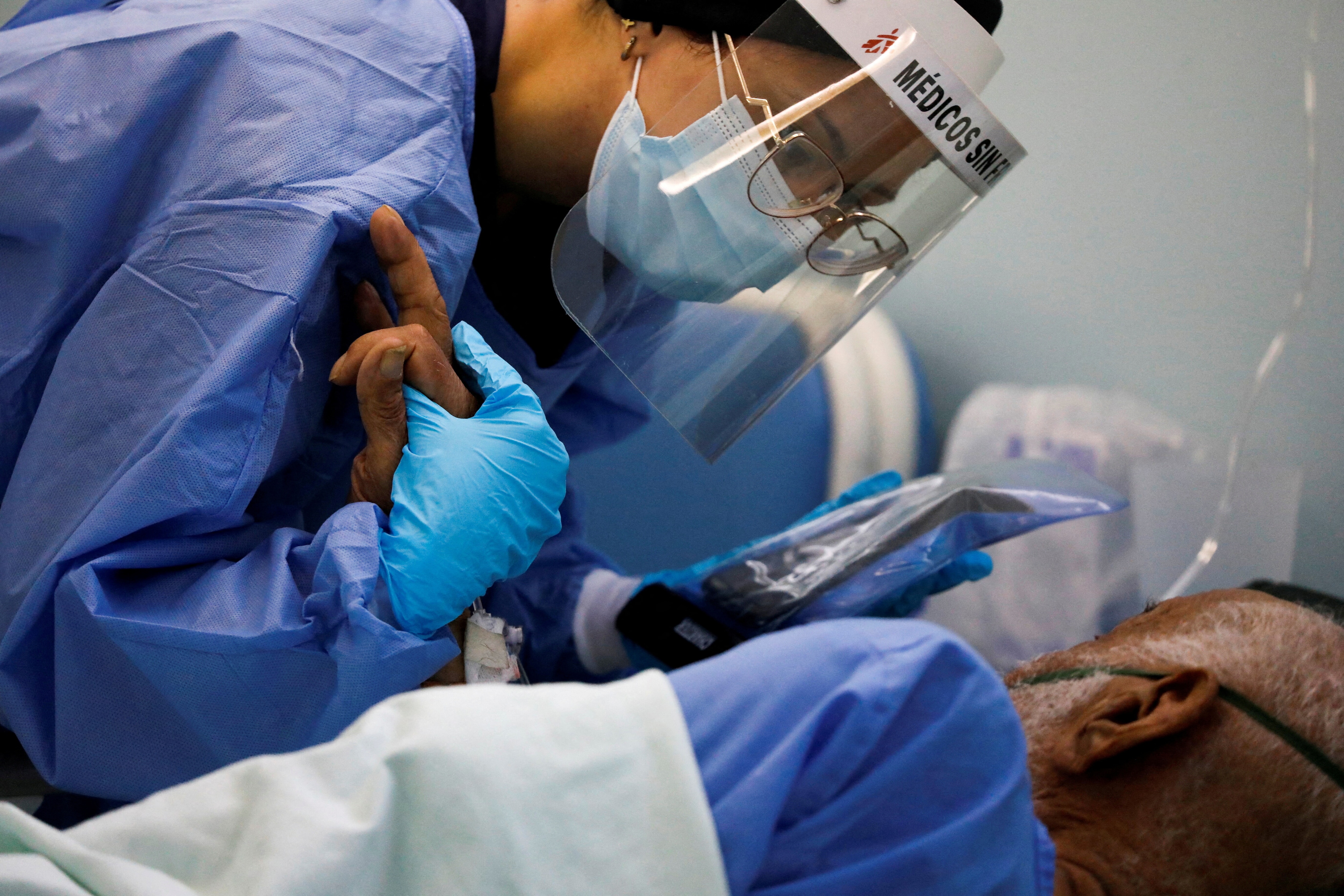 A mental health worker with Doctors Without Borders (MSF) attends to a patient who has the coronavirus disease (COVID-19) at a hospital where the organization is helping address mental health challenges faced by patients with the disease, in Caracas, Venezuela February 1, 2022. Picture taken February 1, 2022