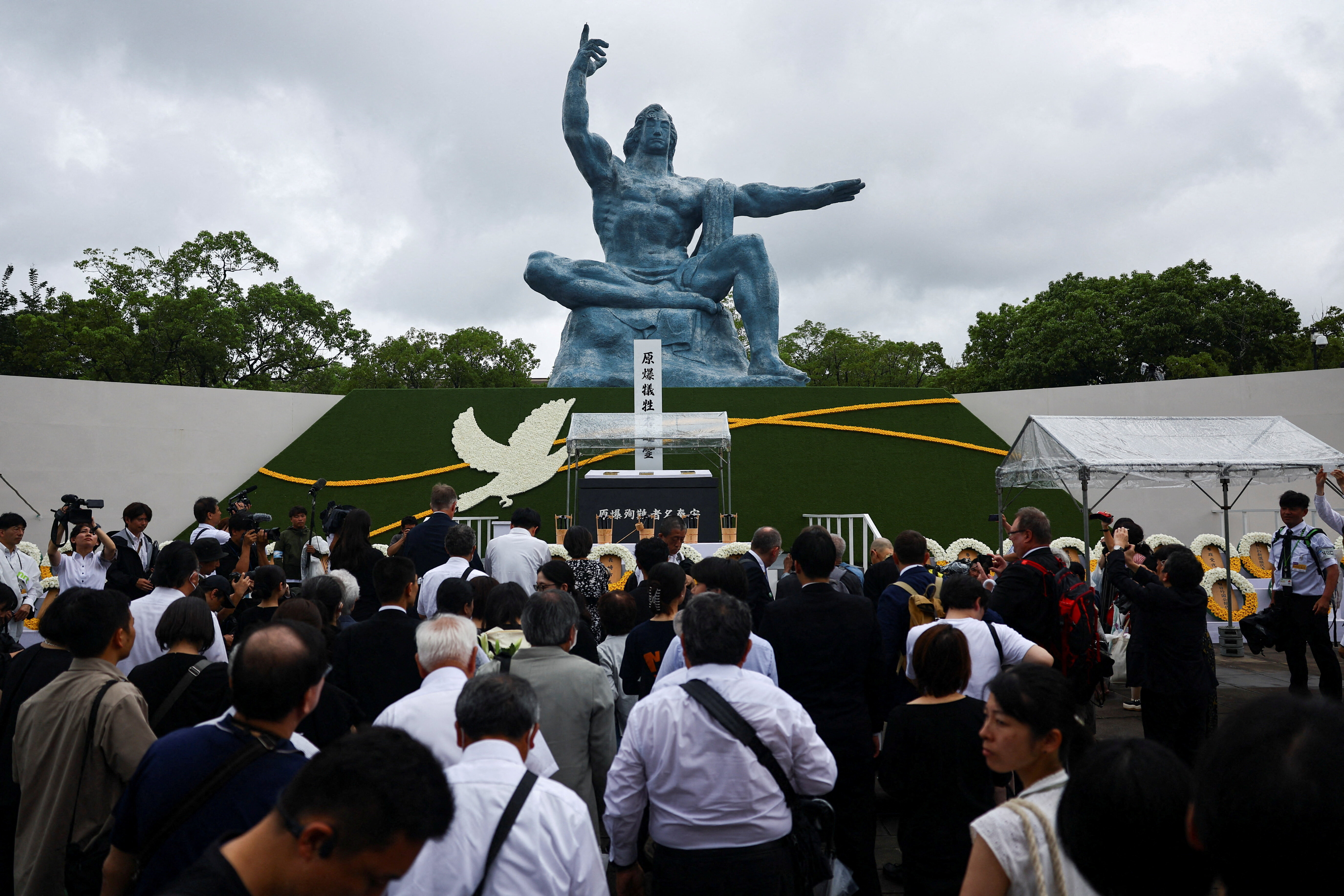 Attendees pray for the victims in front of the Nagasaki Peace Statue on the day of a ceremony commemorating the 80th anniversary of the bombing of the city, at Nagasaki's Peace Park in Nagasaki, southwestern Japan, August 9, 2025.  REUTERS/Issei Kato