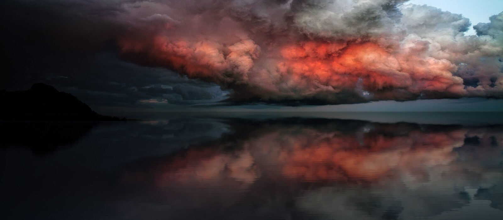 photo of a storm over a still lake
